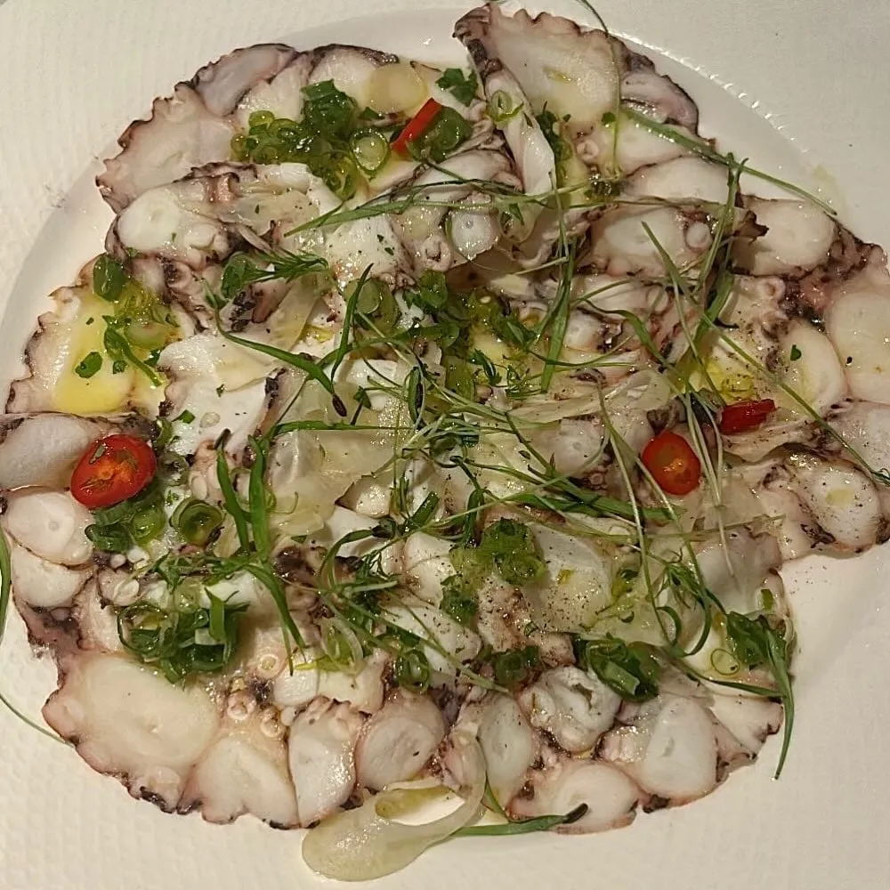 Octopus carpaccio with red chili and baby cilantro